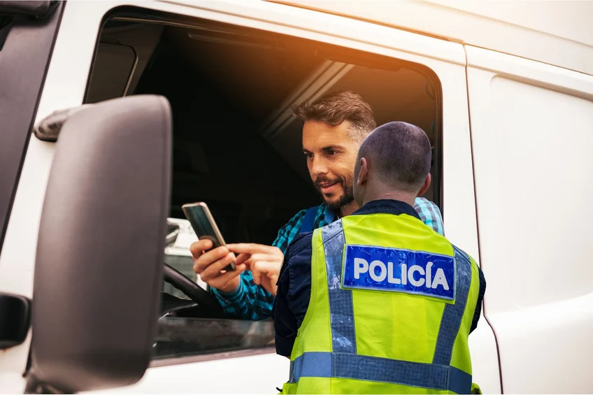 Un agente comprueba en un control de carretera el DeCA que el conductor le muestra en el móvil